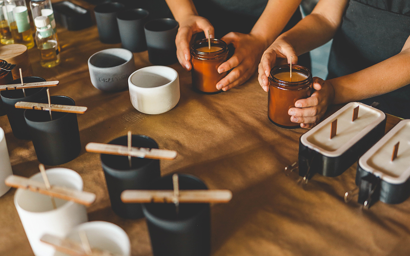 Home-based retailers preparing handmade candles for business storage.